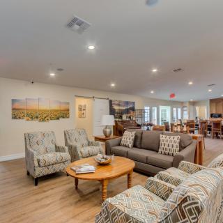 A cozy living room area with comfortable seating and a wooden table in an open-plan space.