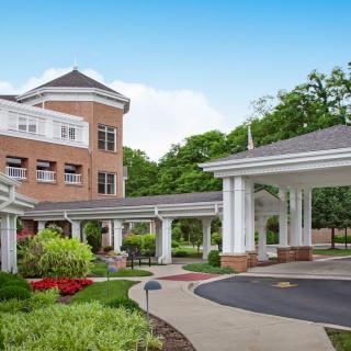 A modern hospital building with landscaped surroundings and a covered driveway.