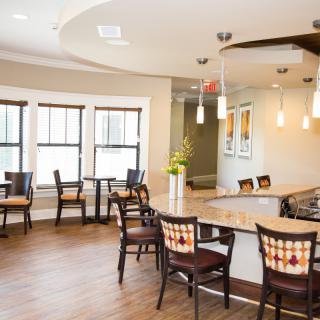 A modern dining area with wooden flooring and elegant pendant lighting.