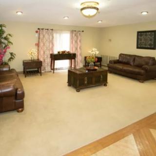 A spacious living room with leather sofas and a central coffee table.