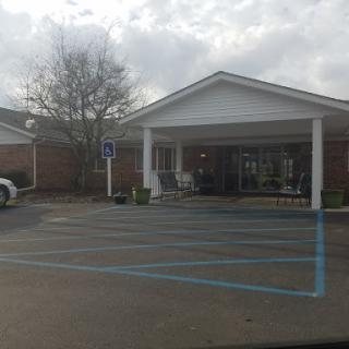 A view of a residential building with a parking lot on a cloudy day.