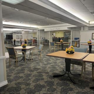 A spacious dining area with neatly arranged tables and chairs, featuring modern decor and bright lighting.