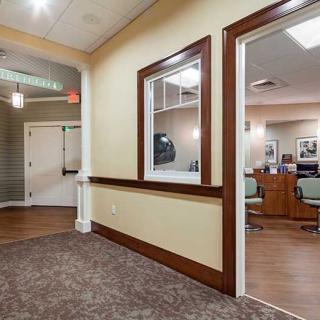 An interior view of an office hallway leading to a waiting area and reception desk.
