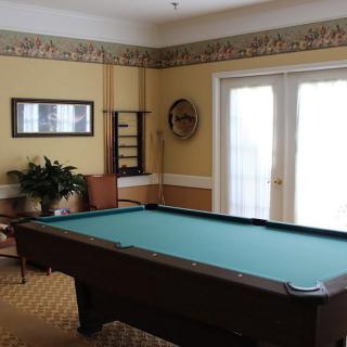 A cozy game room featuring a billiard table and elegant decor.