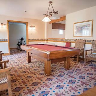 A cozy game room featuring a pool table and comfortable seating.