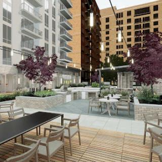 A beautifully designed outdoor communal space featuring modern seating and landscaping in an apartment complex.