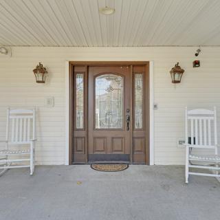 A welcoming front porch with two rocking chairs and a decorative wooden door.