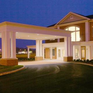 Illuminated building entrance at night with a covered driveway.