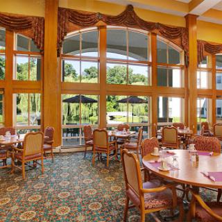 A spacious and elegantly designed dining area with large windows allowing natural light to fill the space.