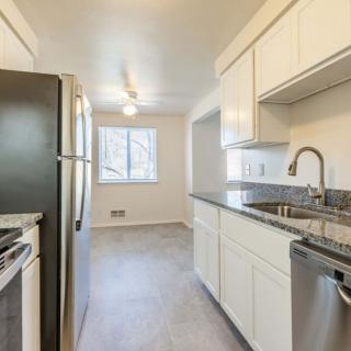 A modern kitchen with stainless steel appliances and white cabinets.