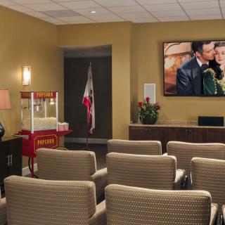 A cozy home theater setup with rows of chairs and a popcorn machine.