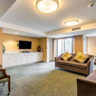 A modern living room with a cozy sofa, wall-mounted television, and stylish lighting.