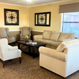 A cozy living room with a beige sofa, matching armchairs, and elegant decor.