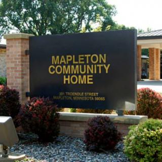 Sign for Mapleton Community Home with landscaping in front.