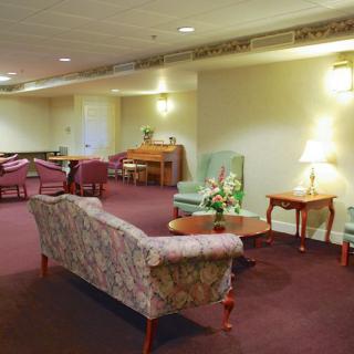 A well-furnished lobby area with sofas, chairs, tables, and soft lighting.