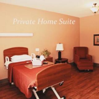 A well-furnished private home suite featuring a comfortable bed and warm lighting.