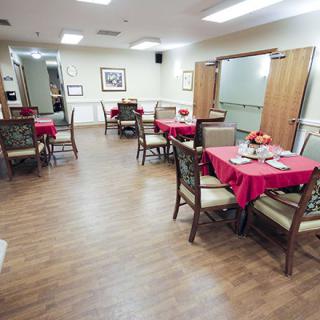 A neatly arranged dining area with tables covered in red tablecloths.