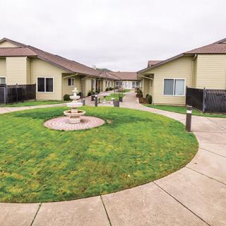 A well-maintained courtyard with a fountain, surrounded by residential buildings and walkways.