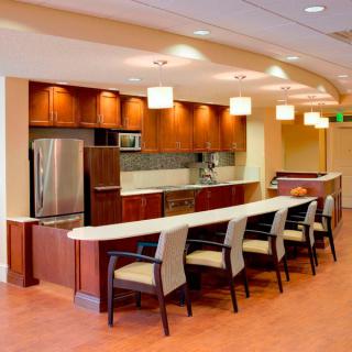 A modern kitchen with a sleek design, featuring stainless steel appliances and a spacious seating area.