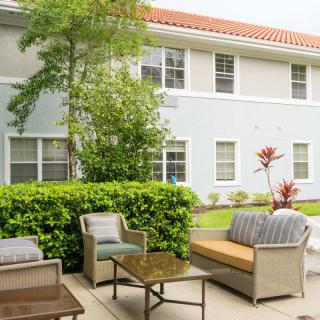 A cozy patio area with outdoor furniture set against a residential building backdrop.