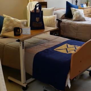 A cozy shared room featuring comfortable beds, decorative pillows, and a versatile table.