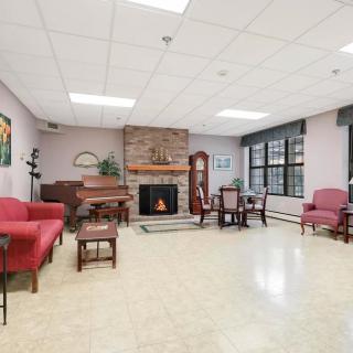 A cozy living room with a fireplace, piano, and comfortable seating.
