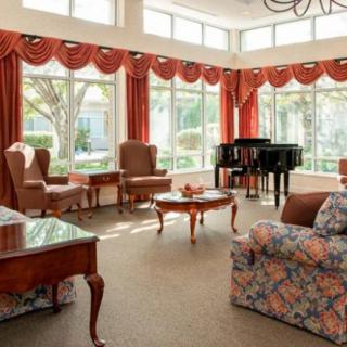 A well-lit living room with elegant furniture and a grand piano.