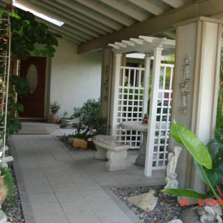 A welcoming home entrance with lush greenery and decorative elements.