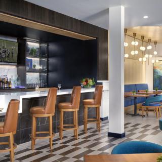 A modern bar with stylish seating and ambient lighting.