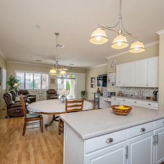 A spacious open-concept kitchen and living area with modern white cabinetry and ample natural lighting.