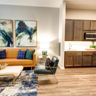 A modern living room with vibrant artwork and an open kitchen.