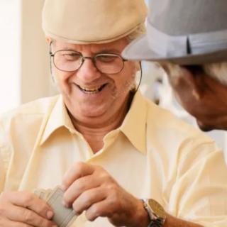 Two elderly men enjoying a conversation indoors.