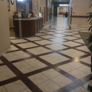 A view of a well-designed hallway featuring patterned tiles and a reception area.