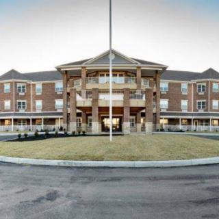 A large, multi-story building with a grand entrance and circular driveway.