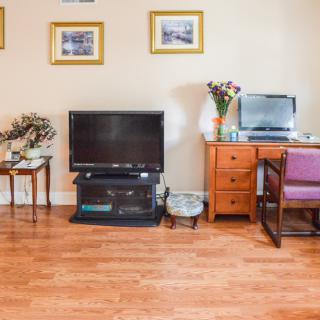 Cozy living room with a television, desk, and decorative elements.