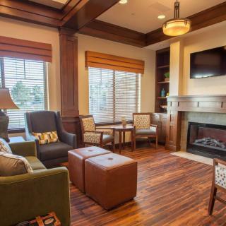 A cozy living room with modern decor, featuring a fireplace and wood flooring.