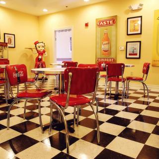 A retro-style diner with red chairs and a black-and-white checkered floor.
