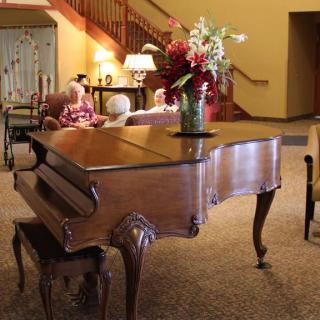 A grand piano adorned with a vase of flowers in a cozy living room setting.