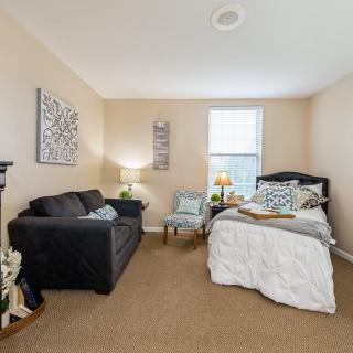 A cozy bedroom with a bed, sofa, and elegant decor.