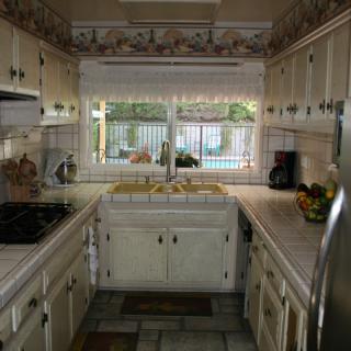 A traditional kitchen space with ample cabinetry and a view through the window.