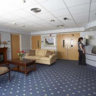 A hotel lobby with a sofa, coffee table, and a person standing near the wall.