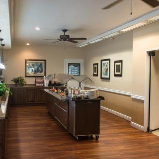A modern kitchen interior with wooden flooring, featuring a central island and ceiling fan.