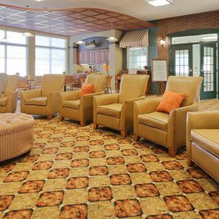 A cozy lounge area with several armchairs and a patterned carpet.