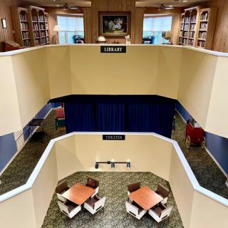Two-story library interior with study tables and bookshelves.