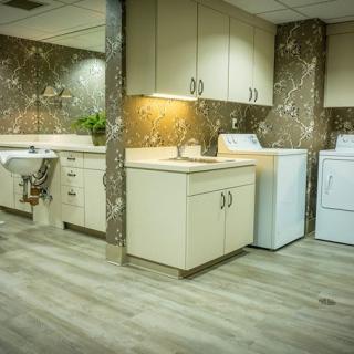 A modern laundry room with a washer, dryer, and ample cabinet space.