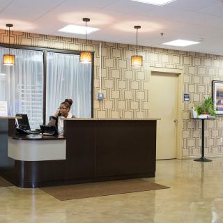 A modern reception area with a front desk and an employee working behind it.