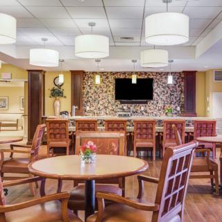 A modern seating area with a bar, featuring wooden furniture and stylish light fixtures.