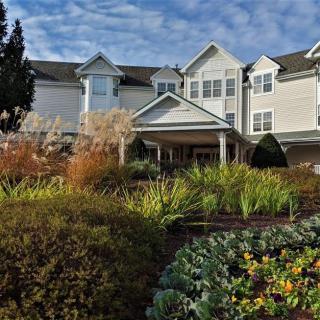 A residential building surrounded by a well-maintained garden with various plants.
