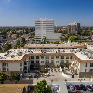 An aerial view of a residential building surrounded by urban infrastructure and cityscape.