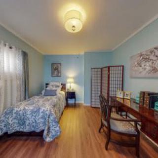 A cozy bedroom with a single bed, desk, and decorative elements.